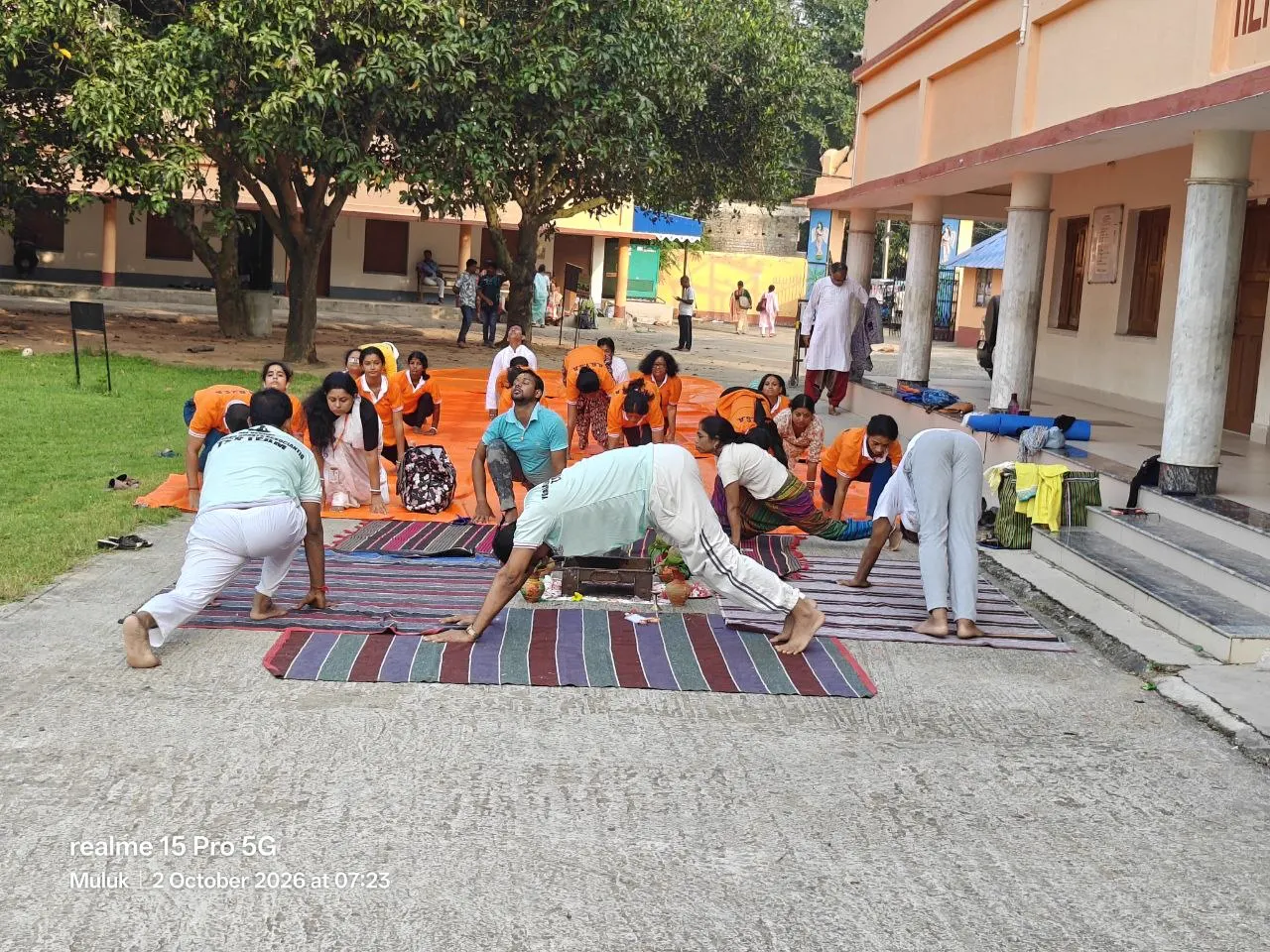 Practitioners hold a low posture on striped mats beside the health centre.